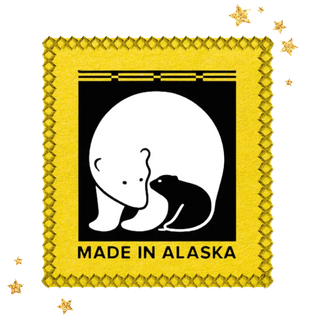 Decorative pillow with bear and fish design and 'Made in Alaska' text on a yellow background | Favicon for Twinkle Toes