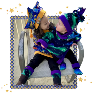 Two children in colorful Twinkle Toes and Wild Outerwear sitting on a chair with decorative border and stars | Twinkle Toes | Palmer, AK